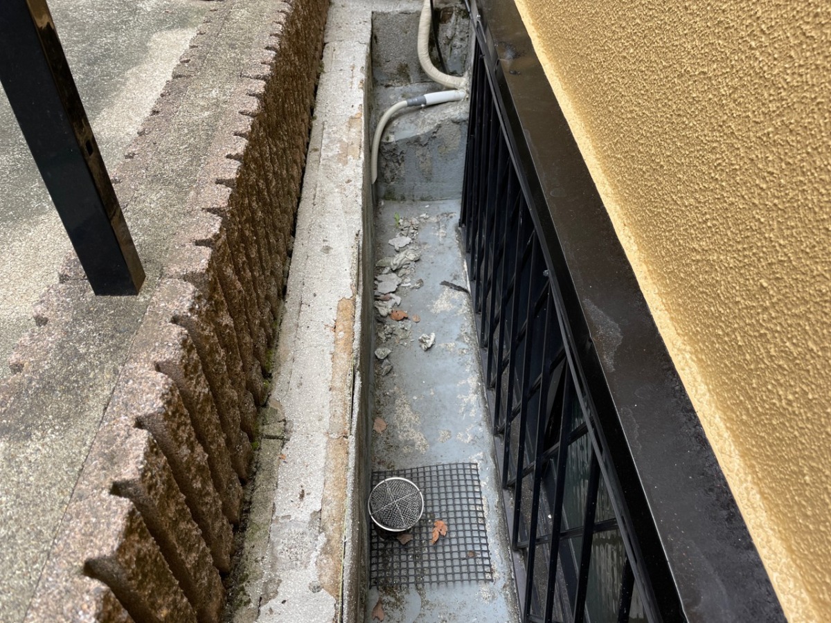 17-outside-before 外構防水の施工前。建物沿いに細長い床が続く。