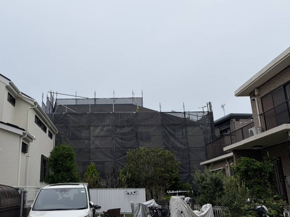 建物の正面側から見た足場とメッシュシート