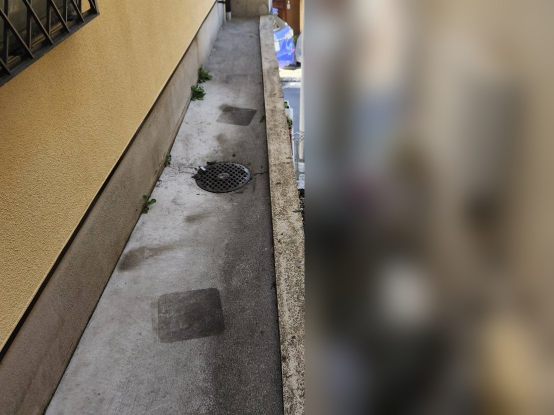 建物脇の通路を清掃