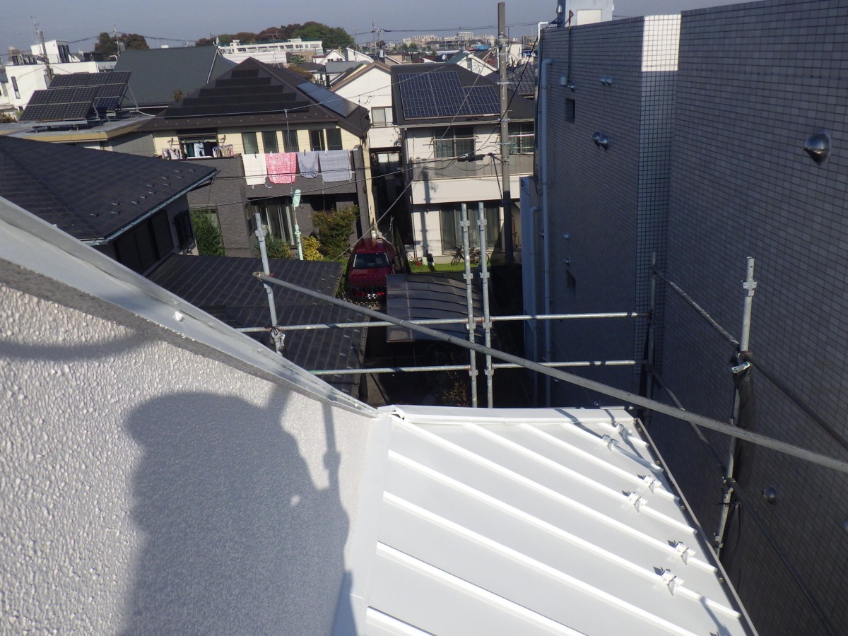 塗装後の金属屋根。継ぎ目が並ぶ屋根面を明るい色で整えています。
