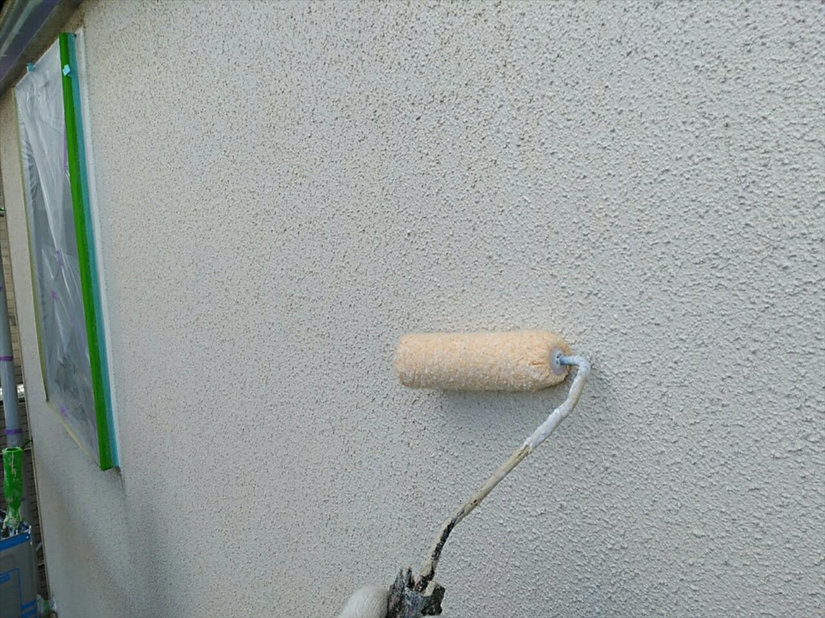 外壁の下塗り。凹凸のある壁面へローラーを当てて施工します。