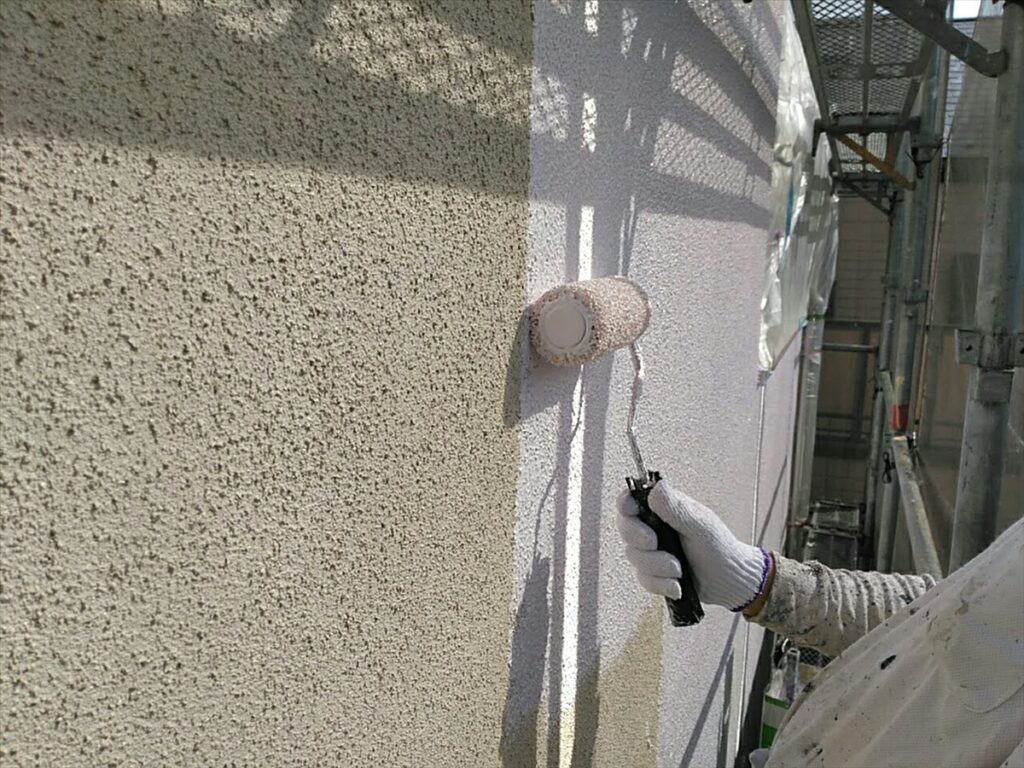 外壁の一回目の中塗り。壁面に材料を塗り広げています。